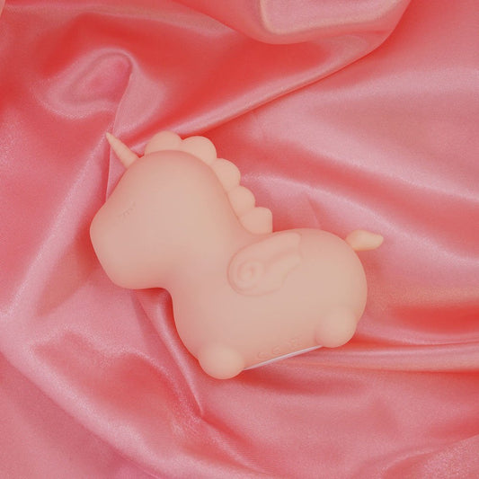 Top view of the Unihorn Heart Throb pulsing clitoral stimulator on soft pink fabric | Flirty Bay adult store and lingerie store