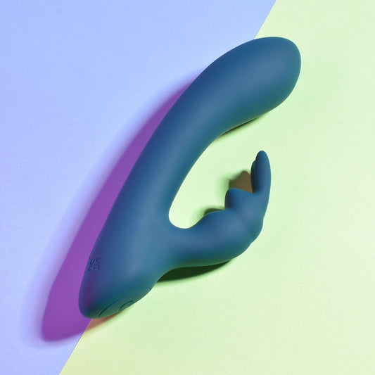 Top Side view of the packaging and teal Playboy Pleasure Lil Rabbit vibrator on a green and blue background | Flirty Bay adult store and lingerie store