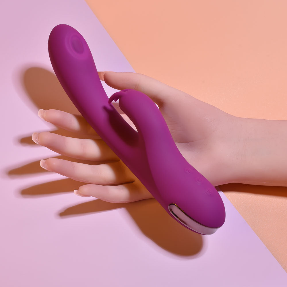 Side view of the Playboy Pleasure Thumpur thumping rabbit vibrator held in a hand, with a pink background| Flirty Bay adult store and lingerie store