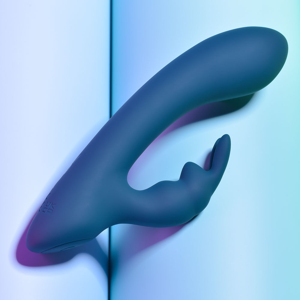 Top Side view of the packaging and teal Playboy Pleasure Lil Rabbit vibrator on a blue background | Flirty Bay adult store and lingerie store