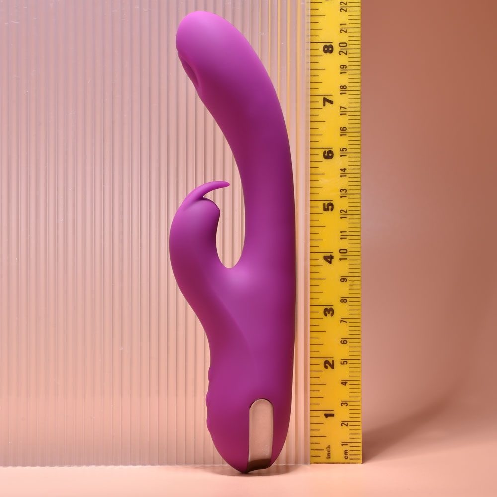 Side view of the Playboy Pleasure Thumpur thumping rabbit vibrator on a purple and pink background, with a ruler shown for size reference | Flirty Bay adult store and lingerie store