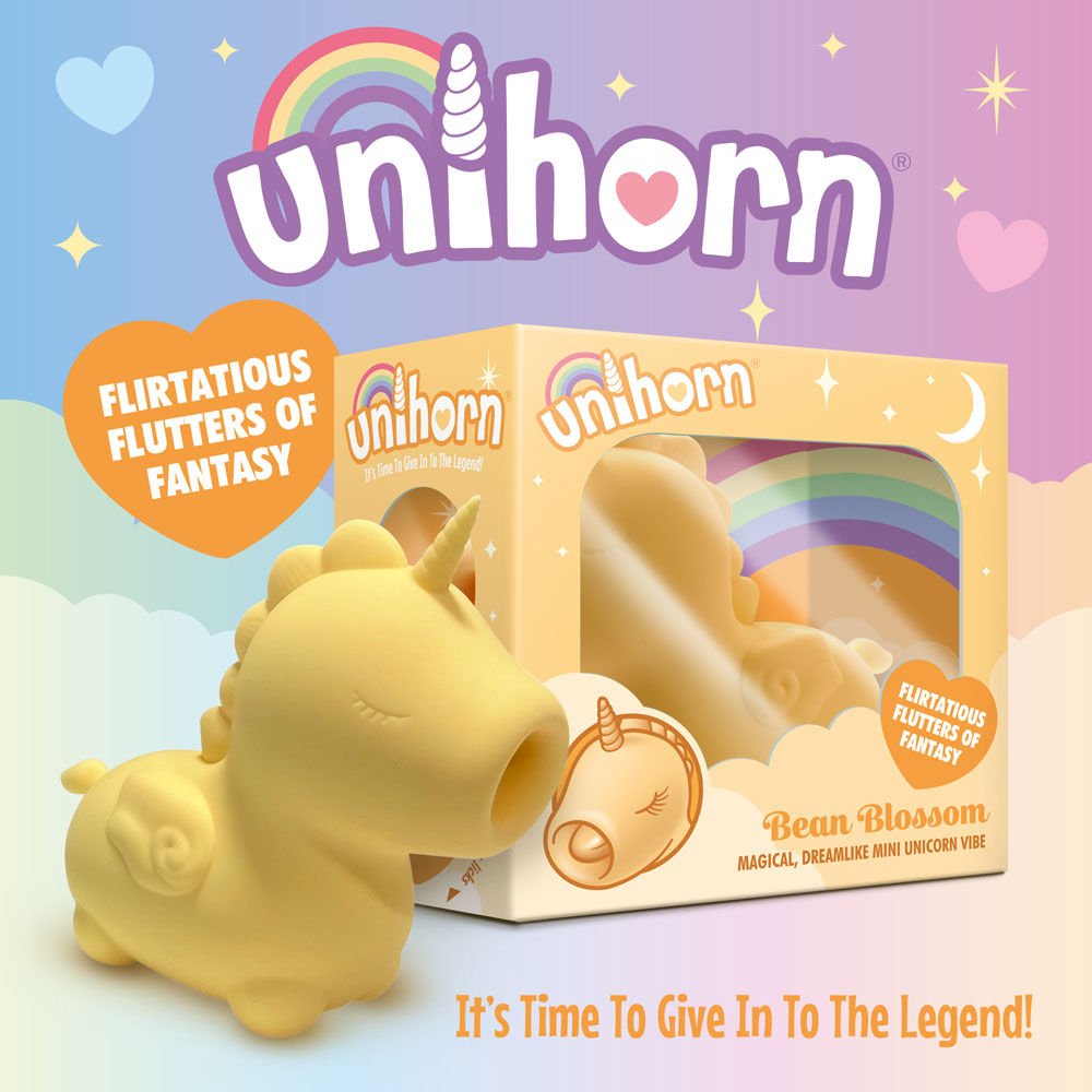 Side view of the packaging and yellow Unihorn Bean Blossom clitoral stimulator, with the small vibrator visible inside, set against a fairy-themed background | Flirty bay adult store and lingerie store