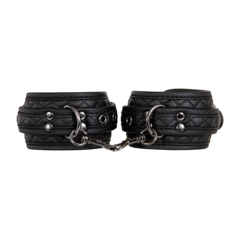 Beginner bondage kit by Adam & Eve with wrist cuffs, ankle cuffs, blindfold, and paddle in padded black vegan leather, focus on cuffs | Flirty bay online adult store, adult toys and lingerie
