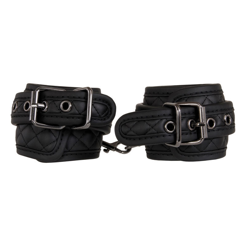Beginner bondage kit by Adam & Eve with wrist cuffs, ankle cuffs, blindfold, and paddle in padded black vegan leather, focus on handcuffs | Flirty bay online adult store, adult toys and lingerie