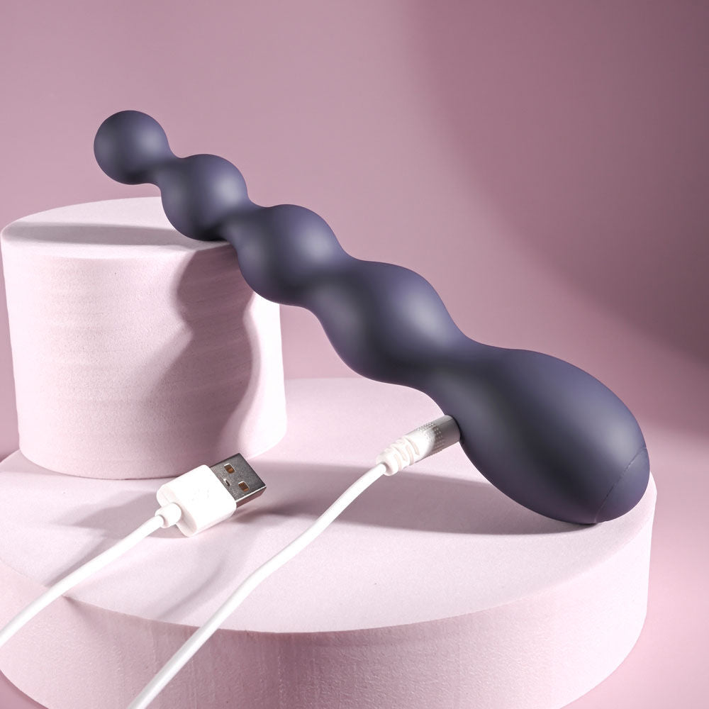 Side view of Zero Tolerance Rumpy Bumpy vibrating anal beads showing the discreet USB charging point on a light purple decor | Flirty Bay, anal plug adult store Australia
