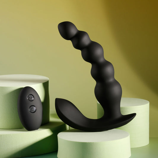 Front view of vibrating black anal beads and wireless remote on yellow-grey background, showcasing sleek body-safe silicone finish | Flirty Bay, anal plug adult store Australia