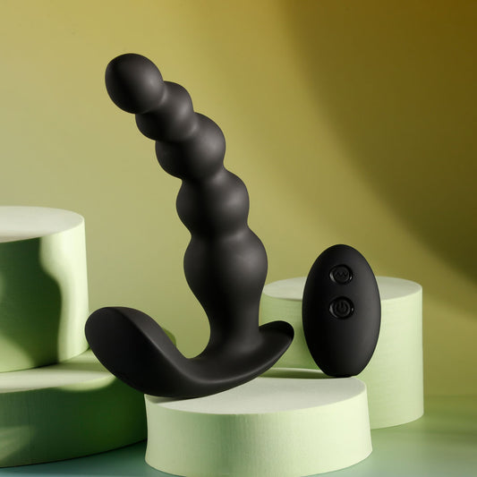 Side view of black vibrating anal beads paired with wireless remote on yellow-grey background | Flirty Bay, anal plug adult store Australia
