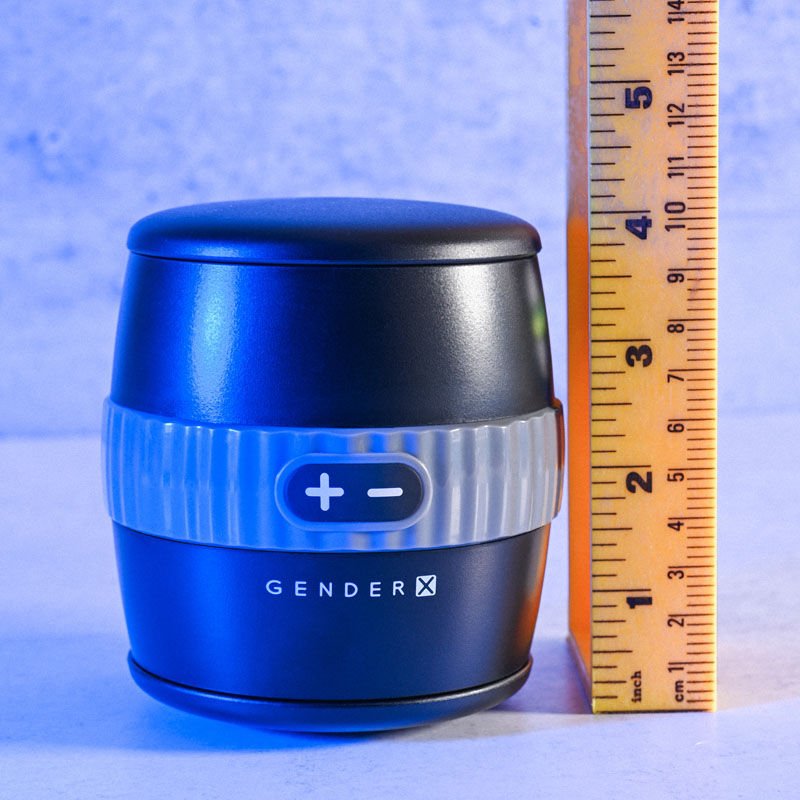 Front view of the Gender X Barrel Of Fun Stroker Male Masturbator next to a ruler for size reference, set against a blue decorative background. | Flirty Bay adult store Perth