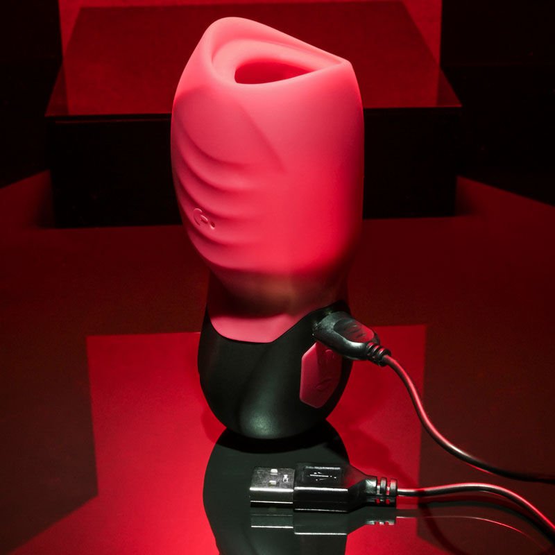 Side view of the Gender X Body Kisses Stroker Male Masturbator highlighting the magnetic charging port, set against a pink and black decorative background. | Flirty Bay adult store Perth