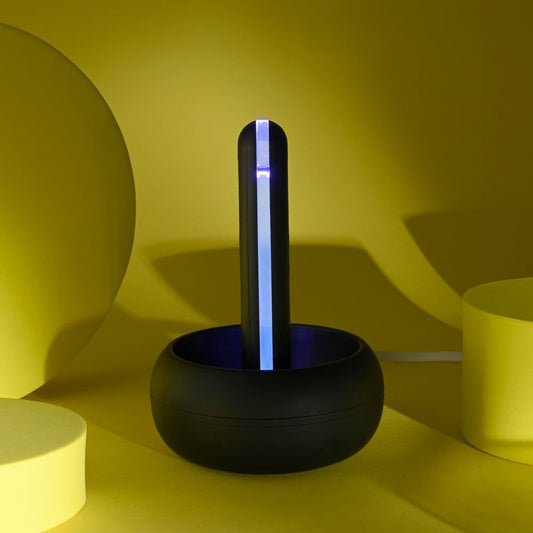 Front view of the Playboy Pleasure End Game vibrating stroker highlighting the charger base on a yellow background | Flirty Bay adult store Perth