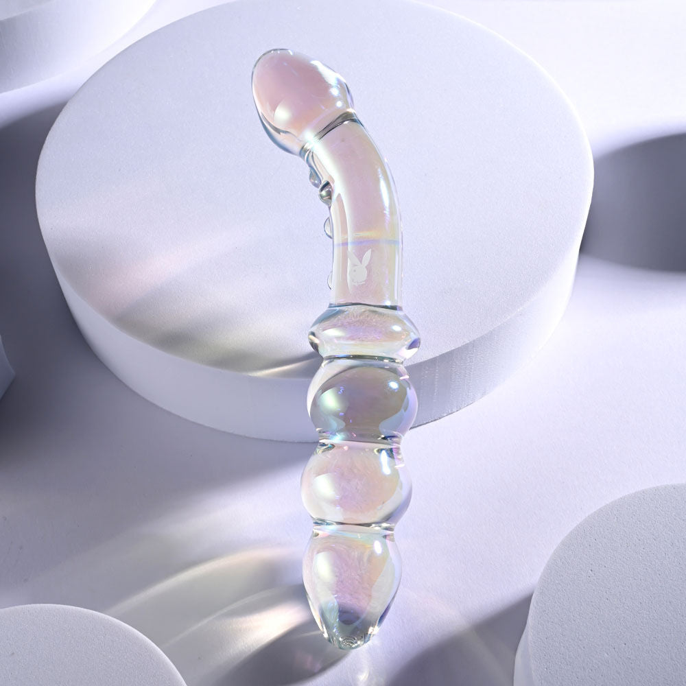 Top view of the dual-ended glass anal beads highlighting the smooth finish and curved shaft on a grey light pink background | Flirty Bay, anal plug adult store Australia